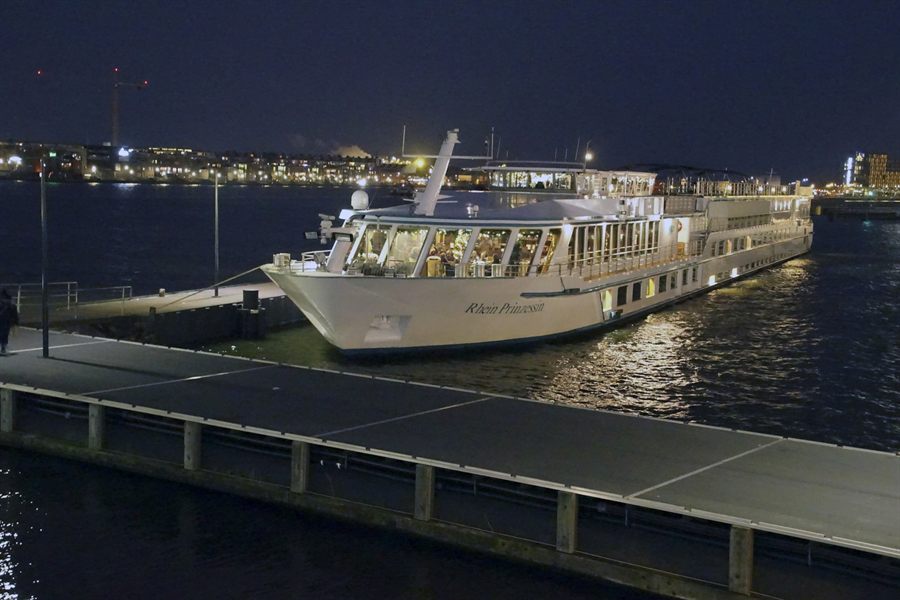 River cruise ship lit up at night, docked on the Rhine at Cologne